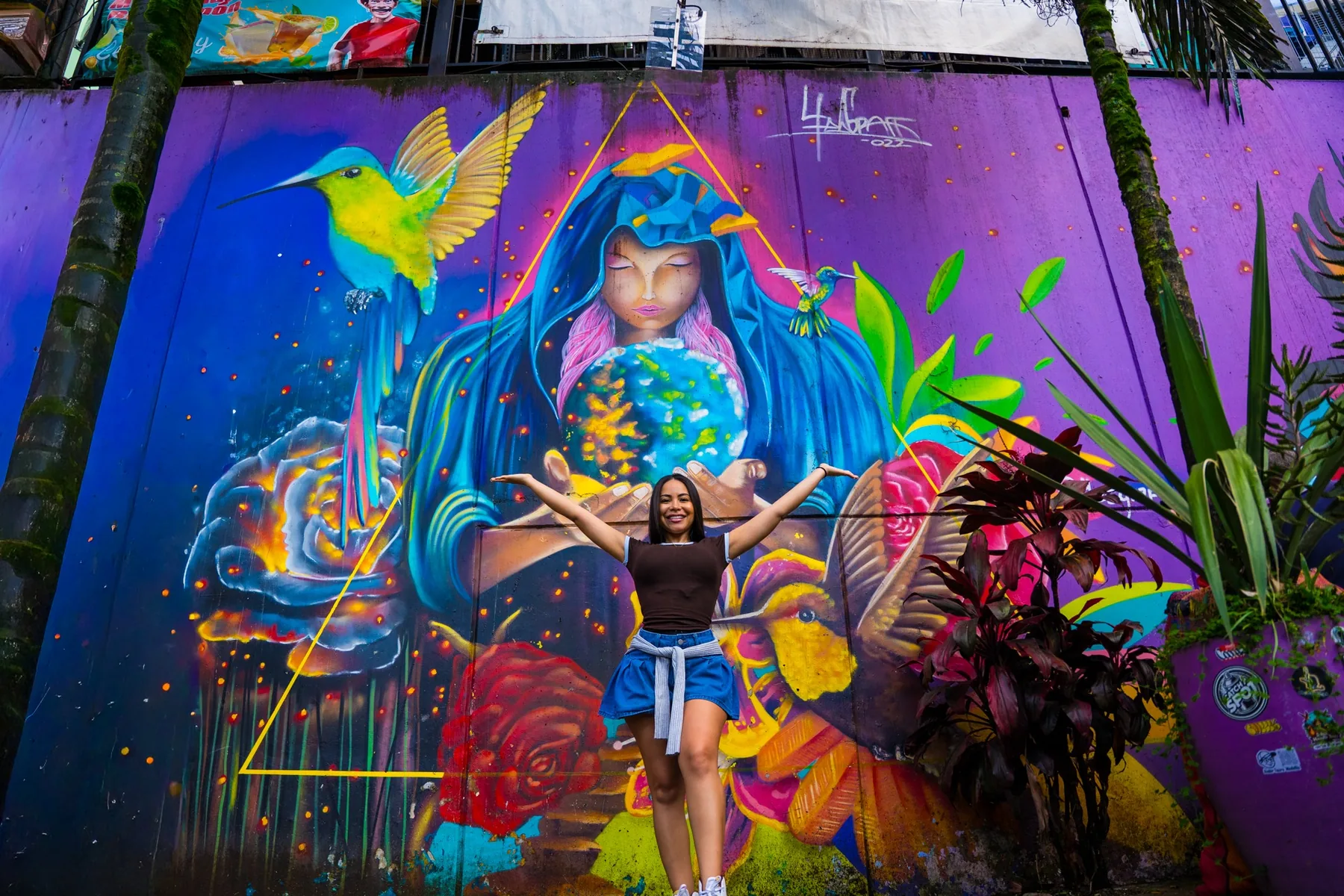 Traveler in front of colorful street art during a Comuna 13 tour in Medellín