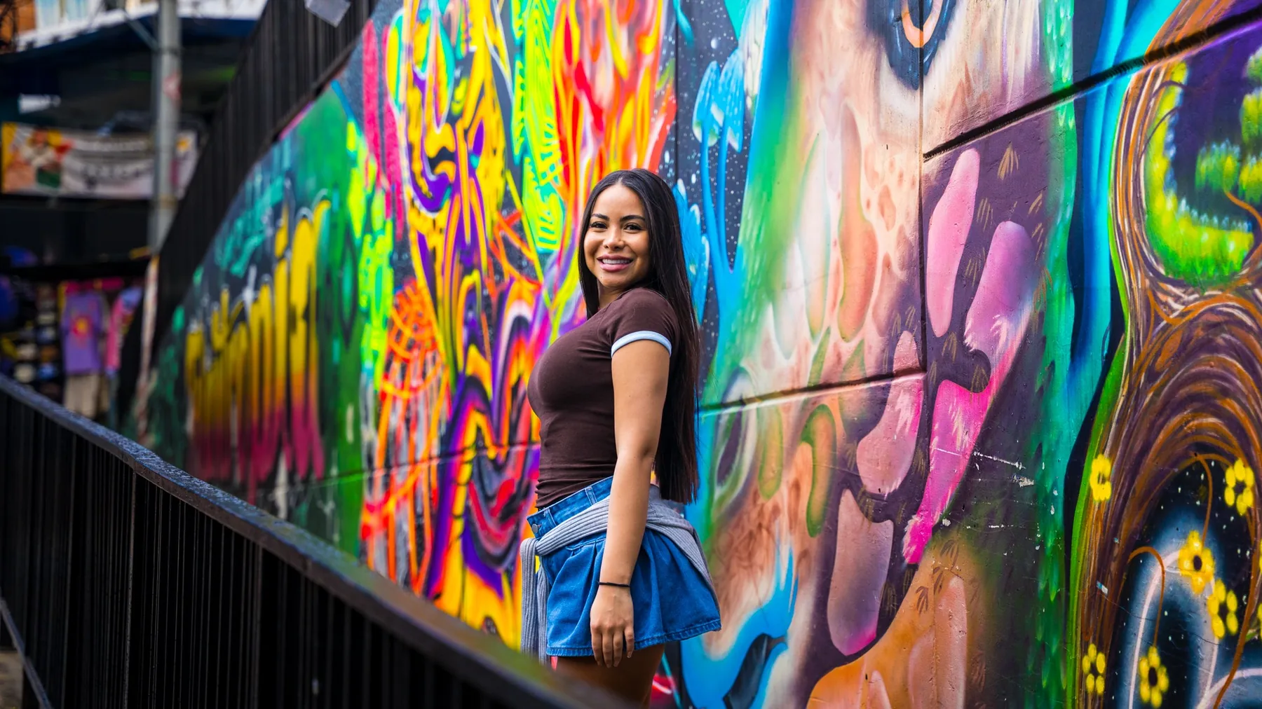 Traveler beside colorful Medellín street art